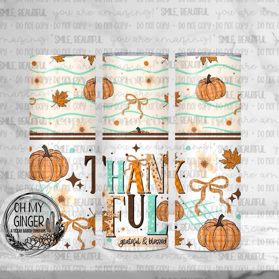 Thankful, Grateful, & Blessed Skinny Tumbler featuring pumpkins, bows, fall leaves and Thankful Grateful Blessed lettering in soft autumn colors by Oh My Ginger
