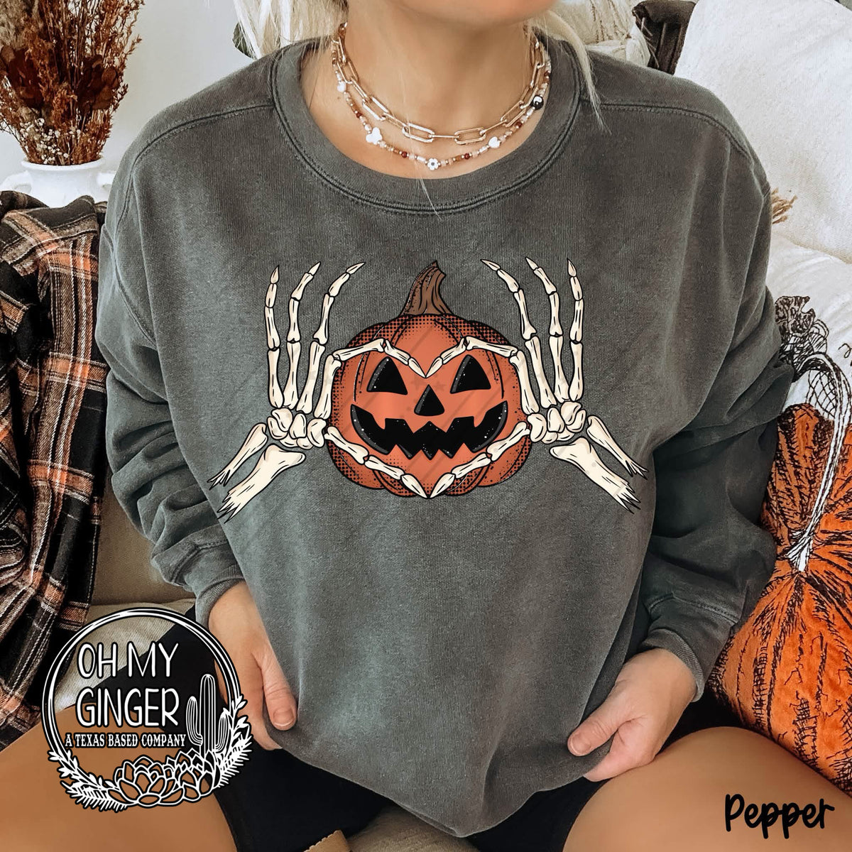 Pumpkin Heart Skellie Hands adult apparel design featuring skeleton hands forming a heart around a pumpkin-inspired centerpiece by Oh My Ginger