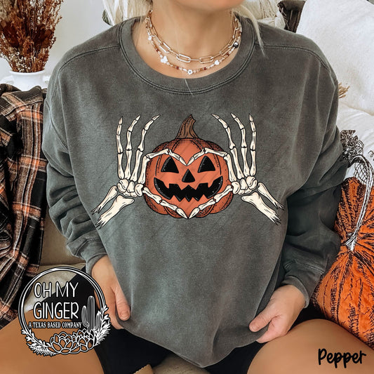 Pumpkin Heart Skellie Hands adult apparel design featuring skeleton hands forming a heart around a pumpkin-inspired centerpiece by Oh My Ginger