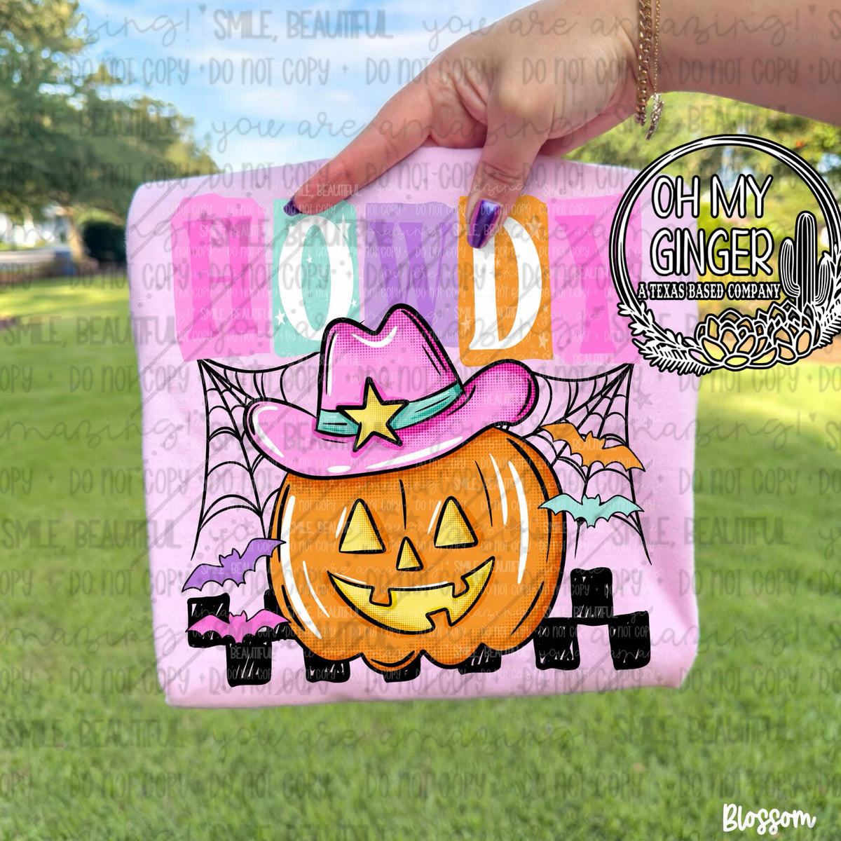 Howdy Pumpkin - Kids design featuring a smiling jack-o'-lantern wearing a bright pink cowboy hat, framed by spiderwebs, bats and colorful HOWDY lettering by Oh My Ginger